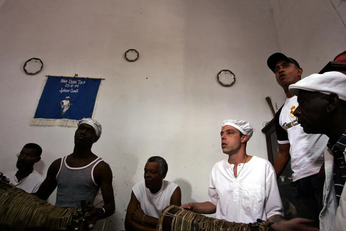 FILE PHOTO: Cuban babalawos or high priests in the Cuban Santeria religion chant and play the drums during a ceremony welcoming the new year in Havana, January 8, 2006. REUTERS/Claudia Daut/File Photo