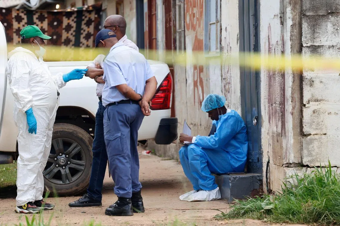Police forensics personnel work at the scene where several people, including three minors, were shot dead in Pretoria, South Africa on Dec 6.