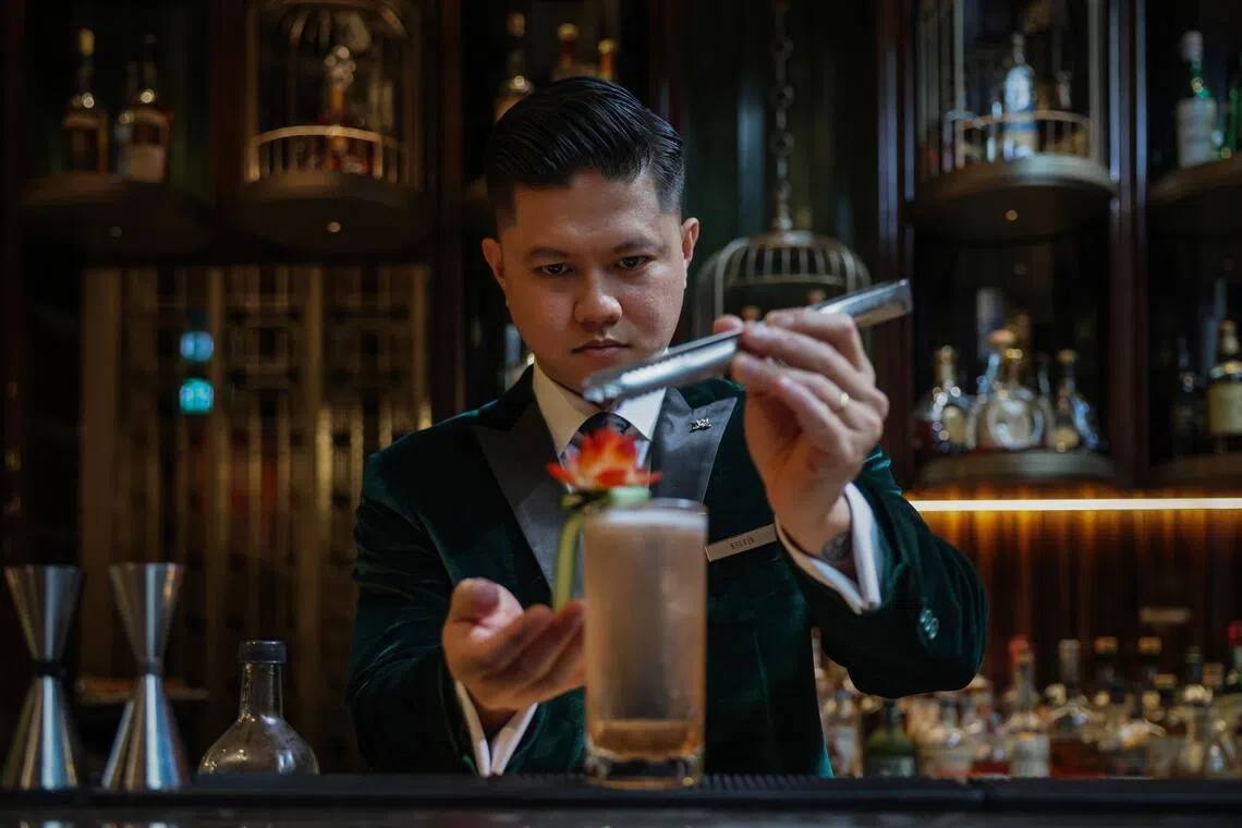ST20260317_202634400725: Gin Tay/ clzero/ Cherie Lok/
Portraits of Kelvin Saquilayan, 34, Head Bartender at The St. Regis Club, poses with a selection of mocktails (from left): Past Perfect, Time Capsule, and Quantum Leap on Mar 17, 2026.