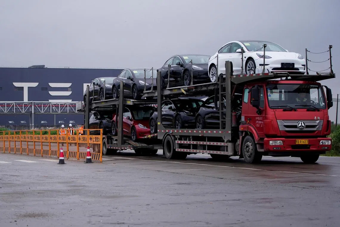 FILE PHOTO: A truck transports new Tesla cars at its factory in Shanghai, China May 13, 2021. REUTERS/Aly Song/File Photo