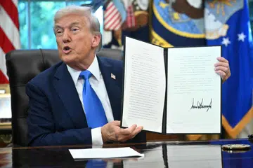 US President Donald Trump holds a signed executive order to increase H-1B visa fee to US$100,000.