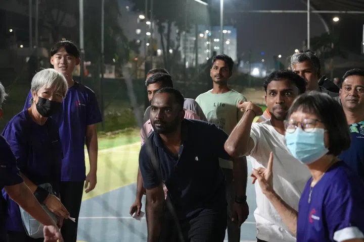 Migrant workers taking on game booths and fitness challenges to earn flea market tokens to redeem essential goods contributed by senior volunteers at Project Silver Impact’s Deepavali celebrations.