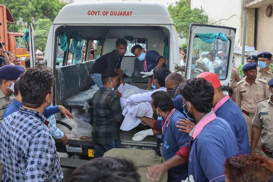 Relatives and hospital staff carry the body of a victim who died in an airplane crash in Ahmedabad, Gujarat, India on Jun 13.