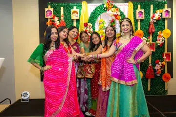 Women wore vibrant traditional attire, particularly shades of green and red, complemented by bangles and mehendi-adorned hands.