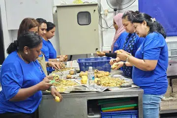 Volunteers from the LISHA Women’s Wing helping with meal preparation at Krishna Free Meals. 