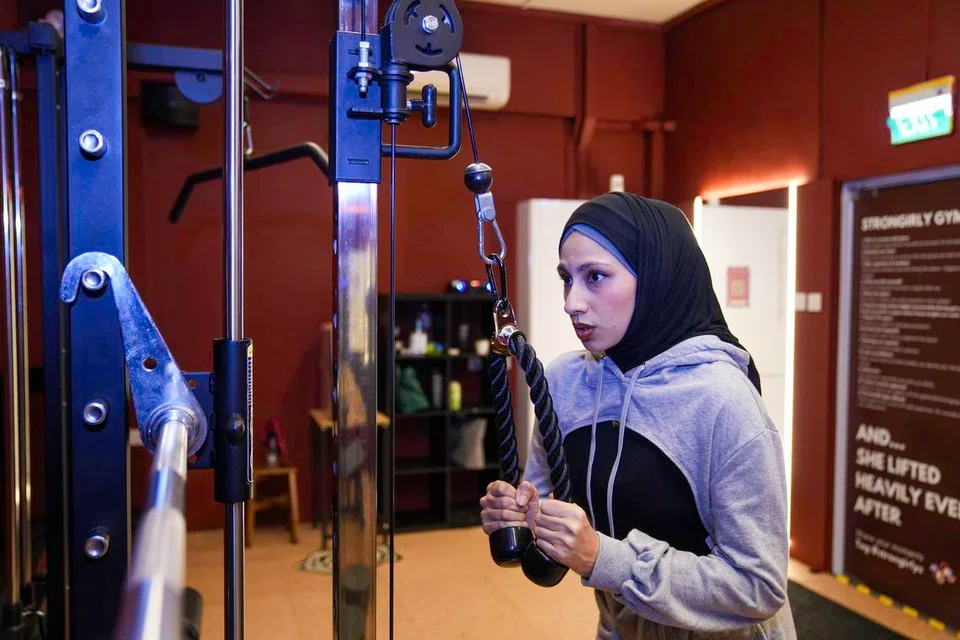 Shireen Taj, 30, founder of StronGirlys, using the cable machine at her women-only gym pod.