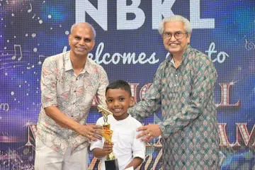 Junior Category champion Sriram Krishnalal receiving the trophy from NBKL adviser V. Bimel Ram (left) and former Nominated Member of Parliament K. Karthikeyan.