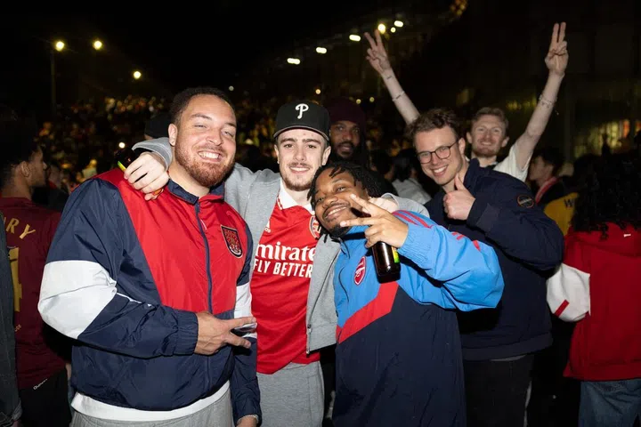 Arsenal fans celebrate their team winning the English Premier League, outside the Emirates Stadium in London on May 20.