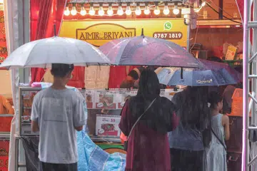 Customers queueing in the rain outside Hillion Mall in Bukit Panjang.