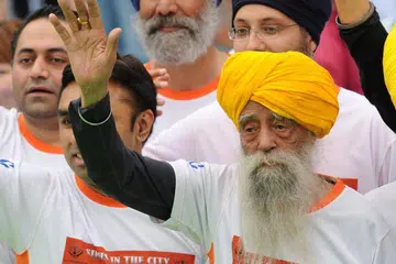 Indian-born British national Fauja Singh waves to the media after crossing the finish line in the 10-km event as part of the Hong Kong Marathon on Feb 24, 2013.