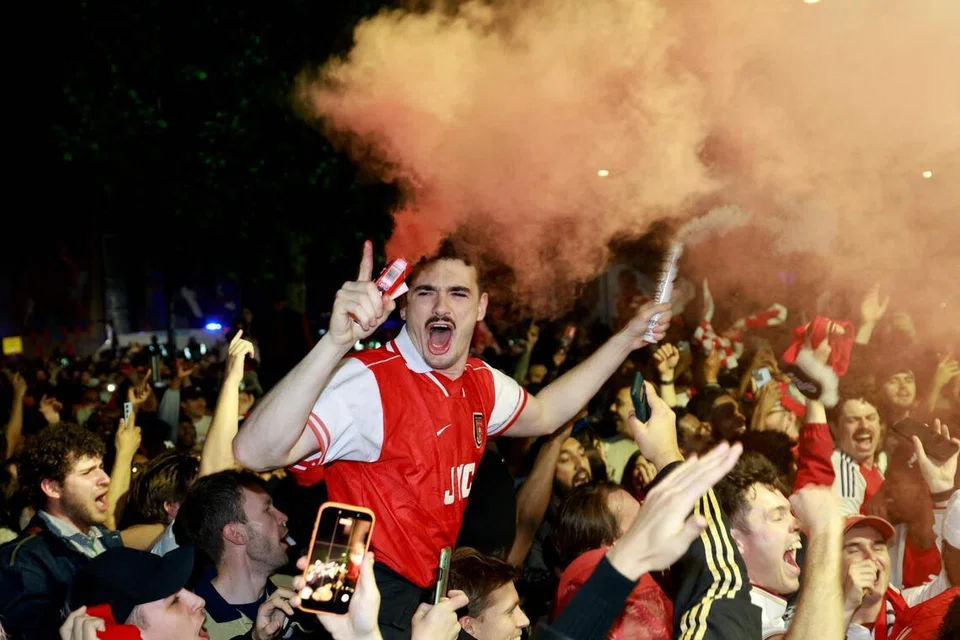 Arsenal fans celebrate their team wining the English Premier League, outside the Emirates Stadium in London on May 20.