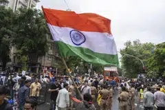 Students supporting the Cockroach Janata Party (CJP) wave an Indian national flag during a celebration after the government accepted their key demands including the resignation of Education Minister Dharmendra Pradhan, in Mumbai, India, on Sunday, July 26, 2026.