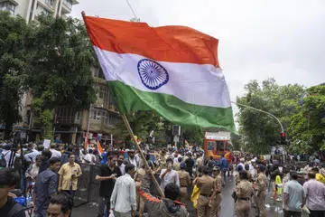 Students supporting the Cockroach Janata Party (CJP) wave an Indian national flag during a celebration after the government accepted their key demands including the resignation of Education Minister Dharmendra Pradhan, in Mumbai, India, on Sunday, July 26, 2026.