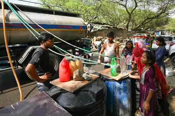Residents fill containers with water supplied by a municipal tanker in New Delhi on May 30, 2024, amid ongoing heatwave. India is enduring a crushing heatwave with temperatures in several cities sizzling well above 45 degrees Celsius (104 degrees Fahrenheit). (Photo by Money SHARMA / AFP)