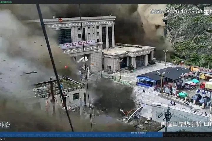 A CCTV footage shows people running away as wall of mud and water destroys buildings in a valley at Nepal-China border, in Gyirong, Tibet region, China August 26, 2026, in this screengrab obtained from a social media video.