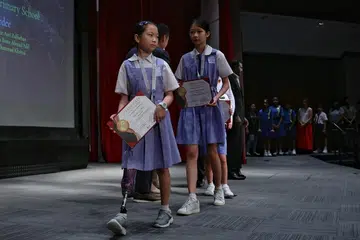 Tao Nan School P6 pupil Debbie Ong, 12, who has had her right leg amputated due to cancer, exiting the stage after receiving her award at the Singapore Silent Heroes Student Award 2026 at Spring Singapore auditorium on May 23, 2026.