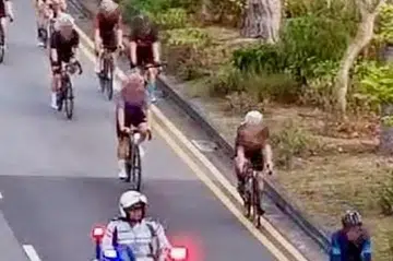 A Traffic Police officer directing a group of cyclists to stop for checks.