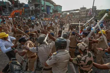 The police use batons as residents attempt to obstruct a demolition drive at the Garib Nagar slum near Bandra East railway station in Mumbai on May 20.