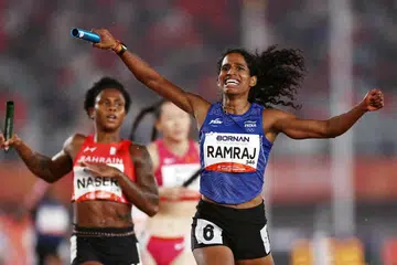 Gold medallist India's Vithya Ramraj celebrates as she crosses the finish line to win the Women's 4 x 400m Relay Final.