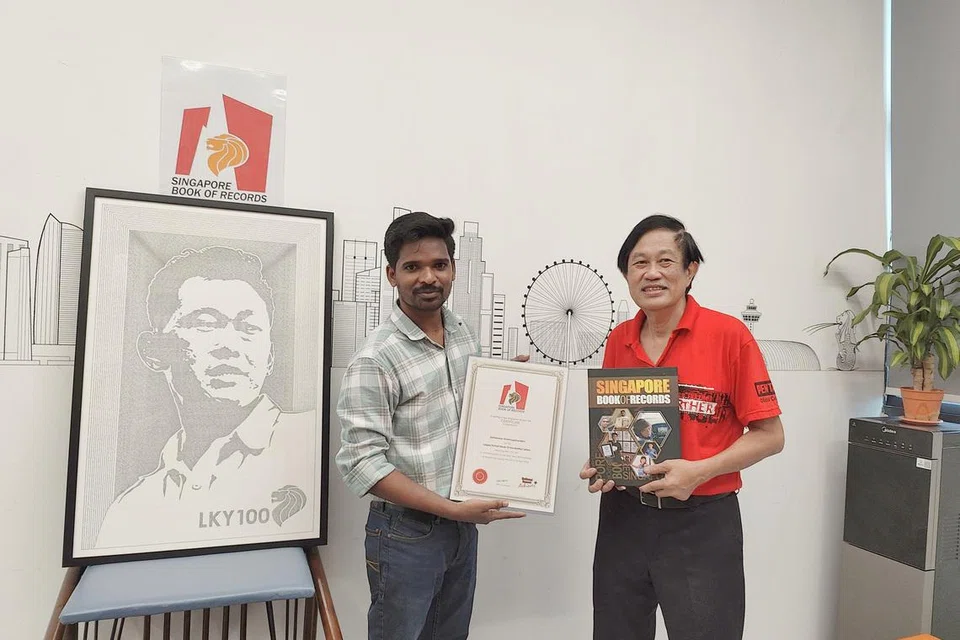 Mr Tamilarasan Shanmuganandam receiving his award from Mr Ong Eng Huat, adjudicator from the Singapore Book of Records.