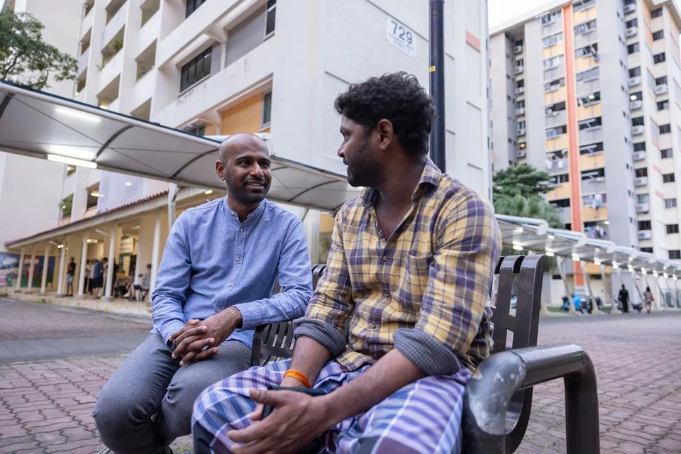 Dr Hamid Razak speaking to a migrant worker at Block 729 in Clementi.