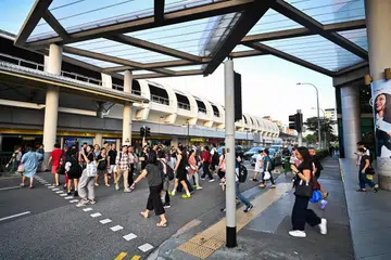 Pedestrians crossing between Tampines MRT station (East-West Line) and Tampines Mall 