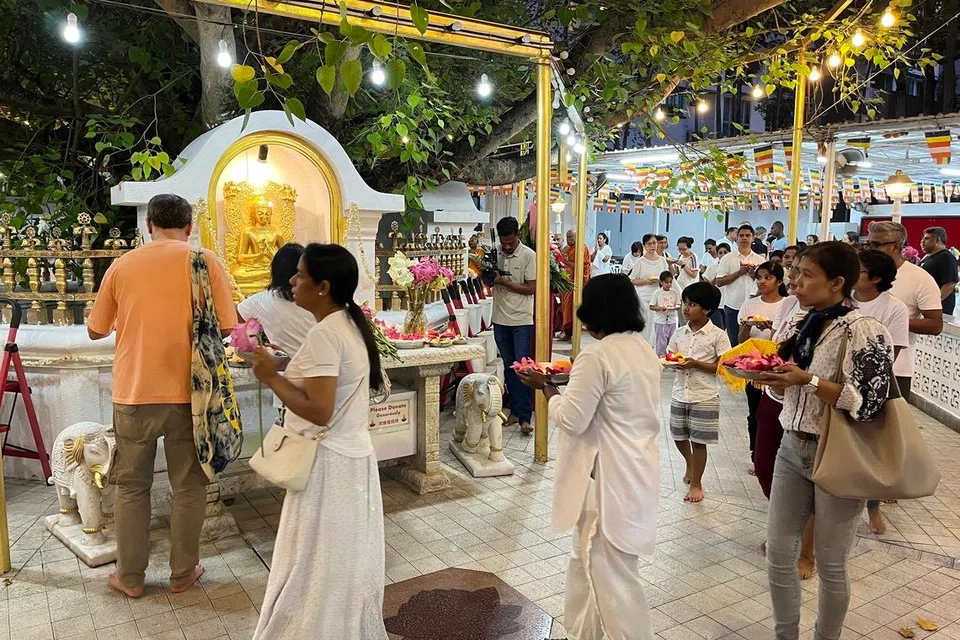 Devotees circled the sacred Bodhi tree shrine in SLT’s compound, and offered lotus stalks and flower-adorned trays of tea lights.