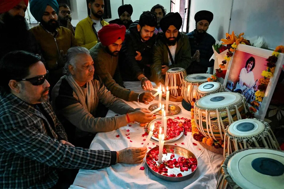 Teachers and students lighting candles in tribute to Zakir Hussain at a university in Amritsar on Dec 16.