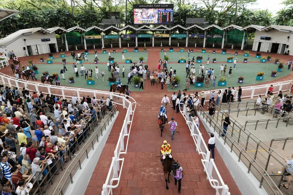 Jockeys race horses parade before a race at the Singapore Turf Club (STC), in Singapore, 05 October 2024.