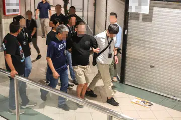 A man being arrested for suspected vape offences during a police raid in the wee hours on Sept 12.