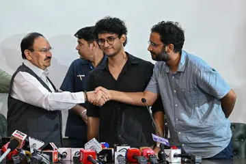 Cockroach Janta Party spokespersons Ashutosh Ranka (right) and Saurav Das (centre) greet India's Health Minister JP Nadda after their meeting in New Delhi on July 25.