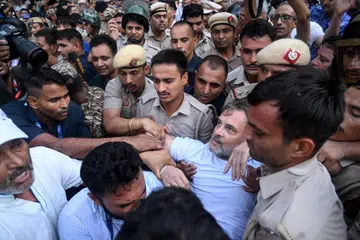 Security personnel detain India's Opposition Leader Rahul Gandhi as he stages a sit-in protest calling for Prime Minister Narendra Modi's resignation outside the latter's residence in New Delhi
