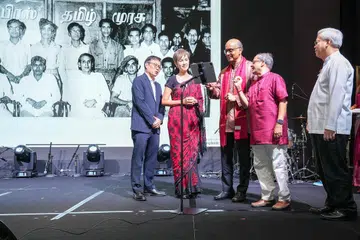 President Tharman Shanmugaratnam scrolling through a specially created photobook during the Tamil Murasu 90th anniversary celebration at Fairmont Singapore on July 6, 2025. Looking on are (from left) SPH Media Editor-in-Chief (English/Malay/Tamil Media Group) Wong Wei Kong, Minister for Digital Development and Information Josephine Teo, Tamil Murasu Editor Raja Segar and CEO of SPH Media Chan Yeng Kit.