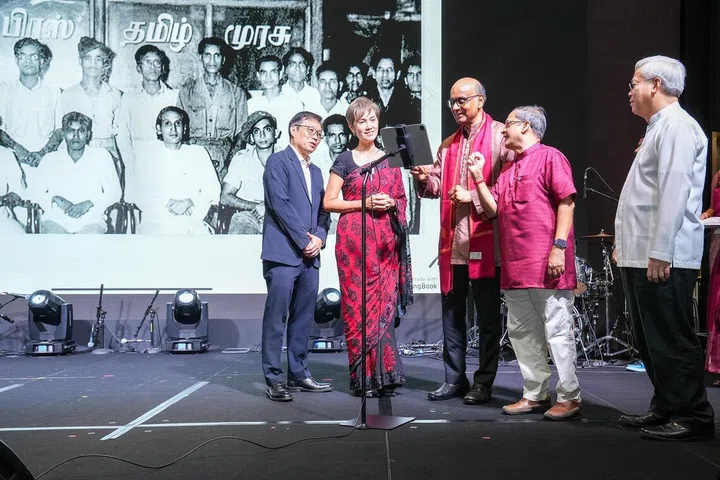 President Tharman Shanmugaratnam scrolling through a specially created photobook during the Tamil Murasu 90th anniversary celebration at Fairmont Singapore on July 6, 2025. Looking on are (from left) SPH Media Editor-in-Chief (English/Malay/Tamil Media Group) Wong Wei Kong, Minister for Digital Development and Information Josephine Teo, Tamil Murasu Editor Raja Segar and CEO of SPH Media Chan Yeng Kit.