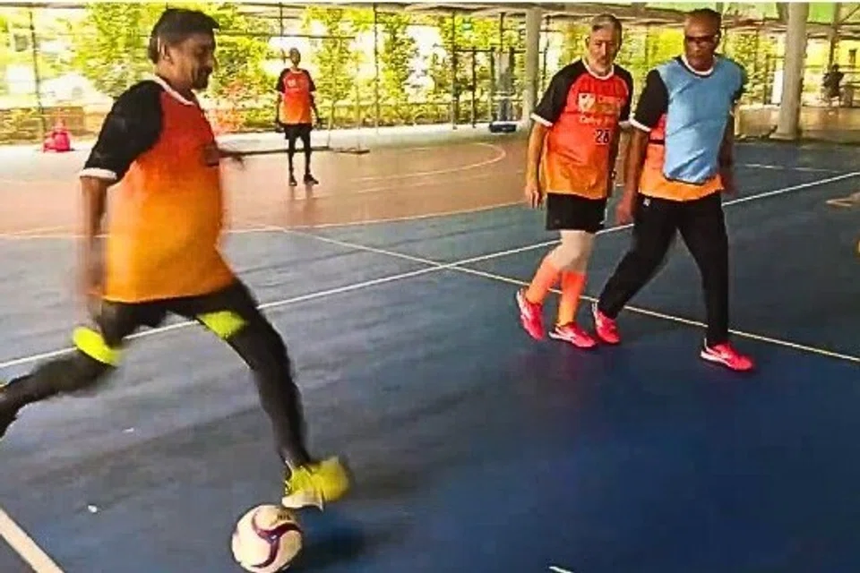  Mr Mathiazhagan (left), Mr Vijayamohan (right) and Mr Divagaran (in a blue jersey) (right), during a training football match.