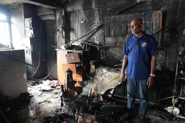 Ambulance driver Mr Muniandy Thangavelu, 55, looks on at his living room and kitchen in his Marsiling Road flat, charred by the explosion of his personal mobility device on Wednesday (Jul 30) evening. 