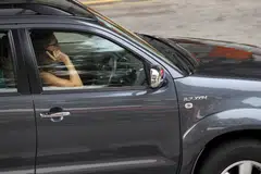 A driver using her handphone while driving along Selegie Road.