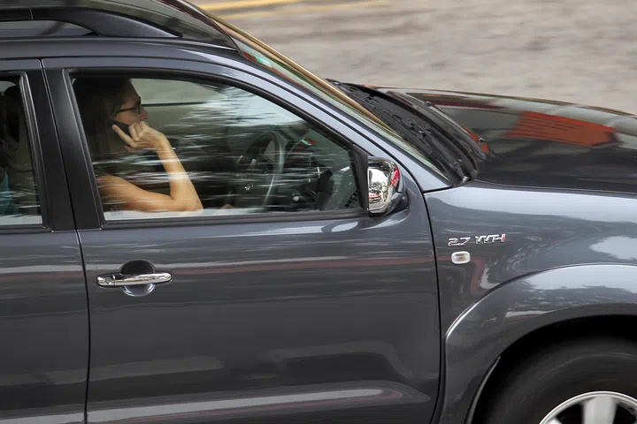 A driver using her handphone while driving along Selegie Road.