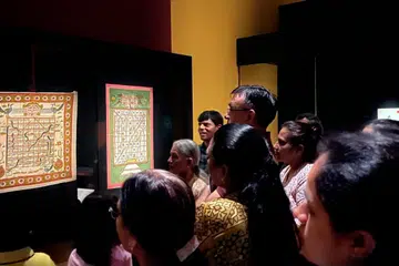 Singapore Jain Religious Society members looking at one of the origins of Snakes and Ladders, the Jain game, Gyan Chaupar or Game of Knowledge.