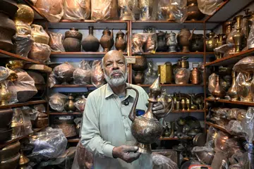 Antique dealer Ahsan Shakeel shows an artefact at his shop selling vintage items in Rawalpindi on October 20, 2026.