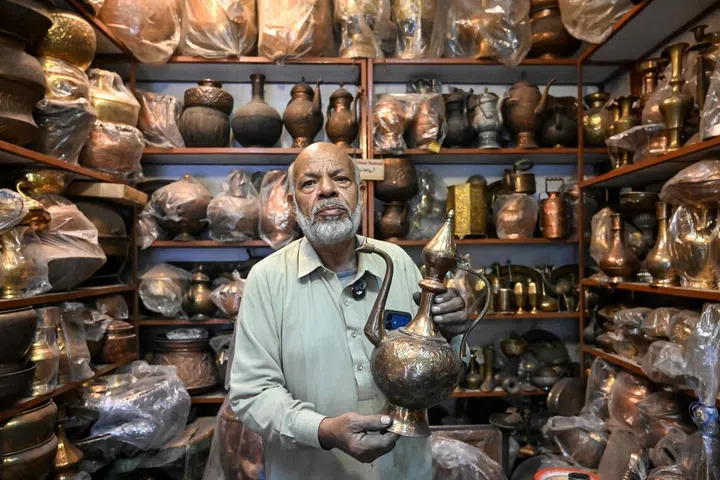 Antique dealer Ahsan Shakeel shows an artefact at his shop selling vintage items in Rawalpindi on October 20, 2026.