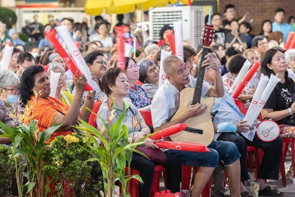 Residents watching the swearing-in ceremony at an area near Yew Tee MRT station