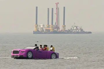 Tourists ride the Rolls-Royce inspired boat across the Arabian Sea off the Juhu Beach on Dec 2.
