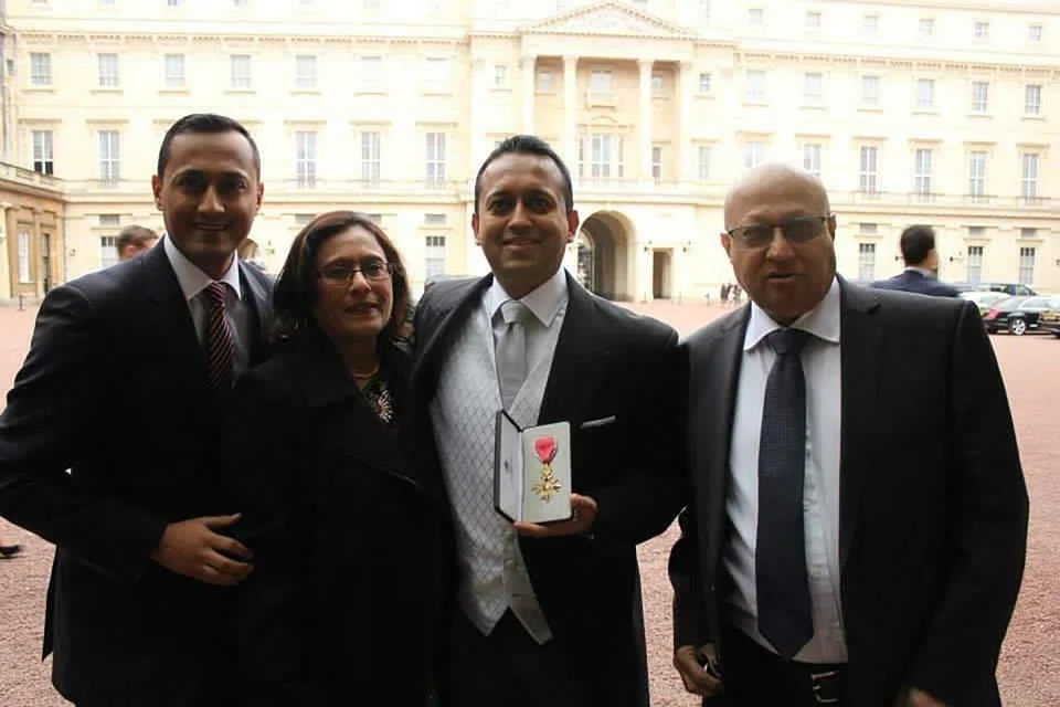 With his brother and parents after he was awarded the Officer of the Order of the British Empire in 2014 for his contribution to British foreign policy and diversity.