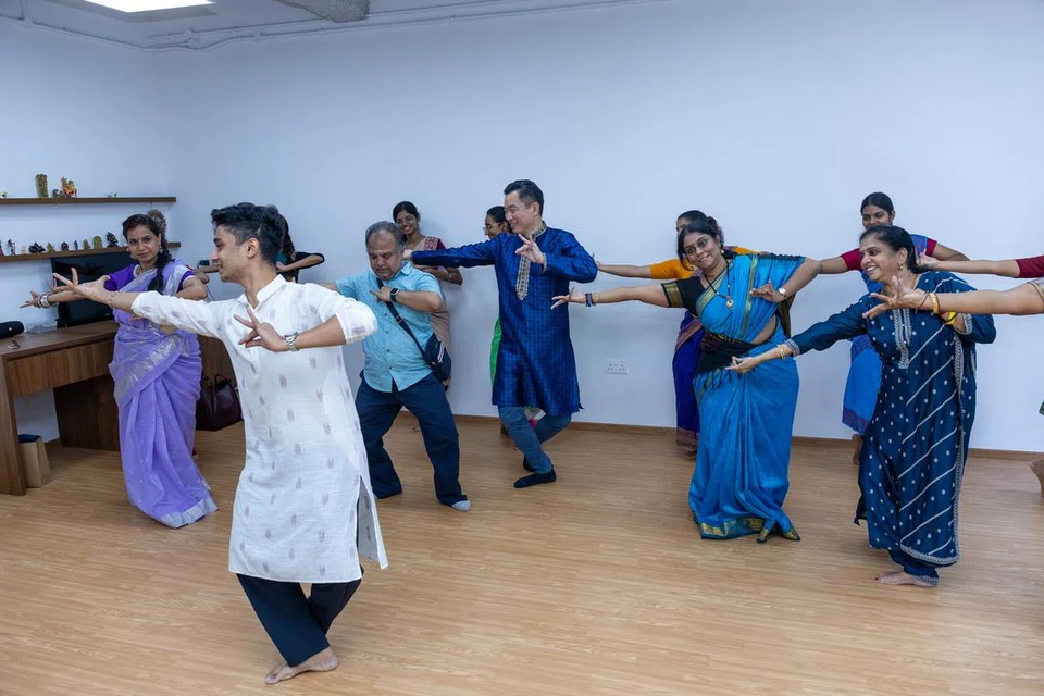 Senior Parliamentary Secretary Eric Chua trying out bharatanatyam steps during a tour of the SIFAS Middle Road campus.
