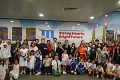Parents and students pose with their shortlisted artworks alongside Mayor of Central Singapore and MP for Jalan Besar GRC Denise Phua at Bayfront MRT station.