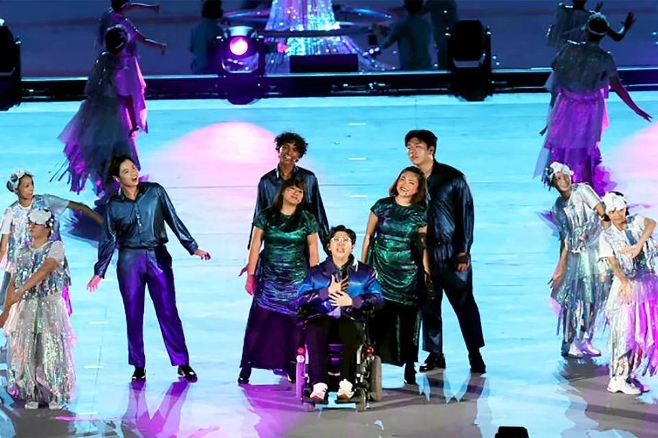 Singer-songwriter Sky Shen (centre), accompanied by six vocalists from the Music and Drama Company as well as dancers from Ministry of Education Schools, singing March On With Me during Chapter 5 of National Education Show 2 at the National Stadium on July 18, 2026. 