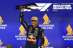 Red Bull's Max Verstappen celebrates with a trophy on the podium after winning the Singapore Grand Prix.