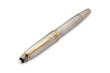 The writing instrument features a sterling silver cap and body accented by yellow-toned metal highlights, and an 18K gold nib.