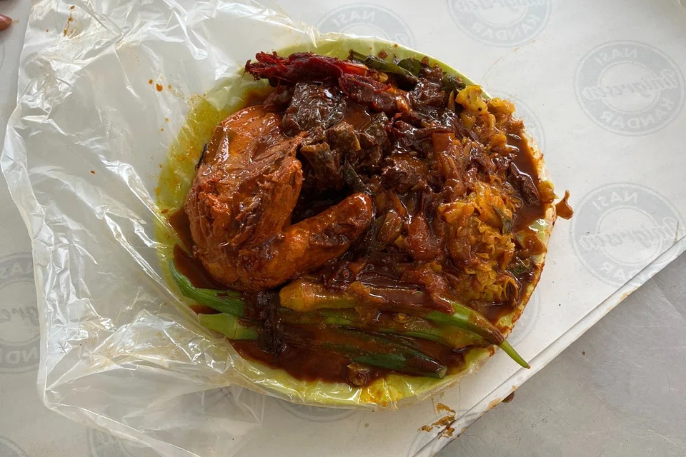 A plate of white rice with sambal prawn, curried chicken and mutton with a side of cabbage and ladyfingers at Nasi Kandar Imigresen.